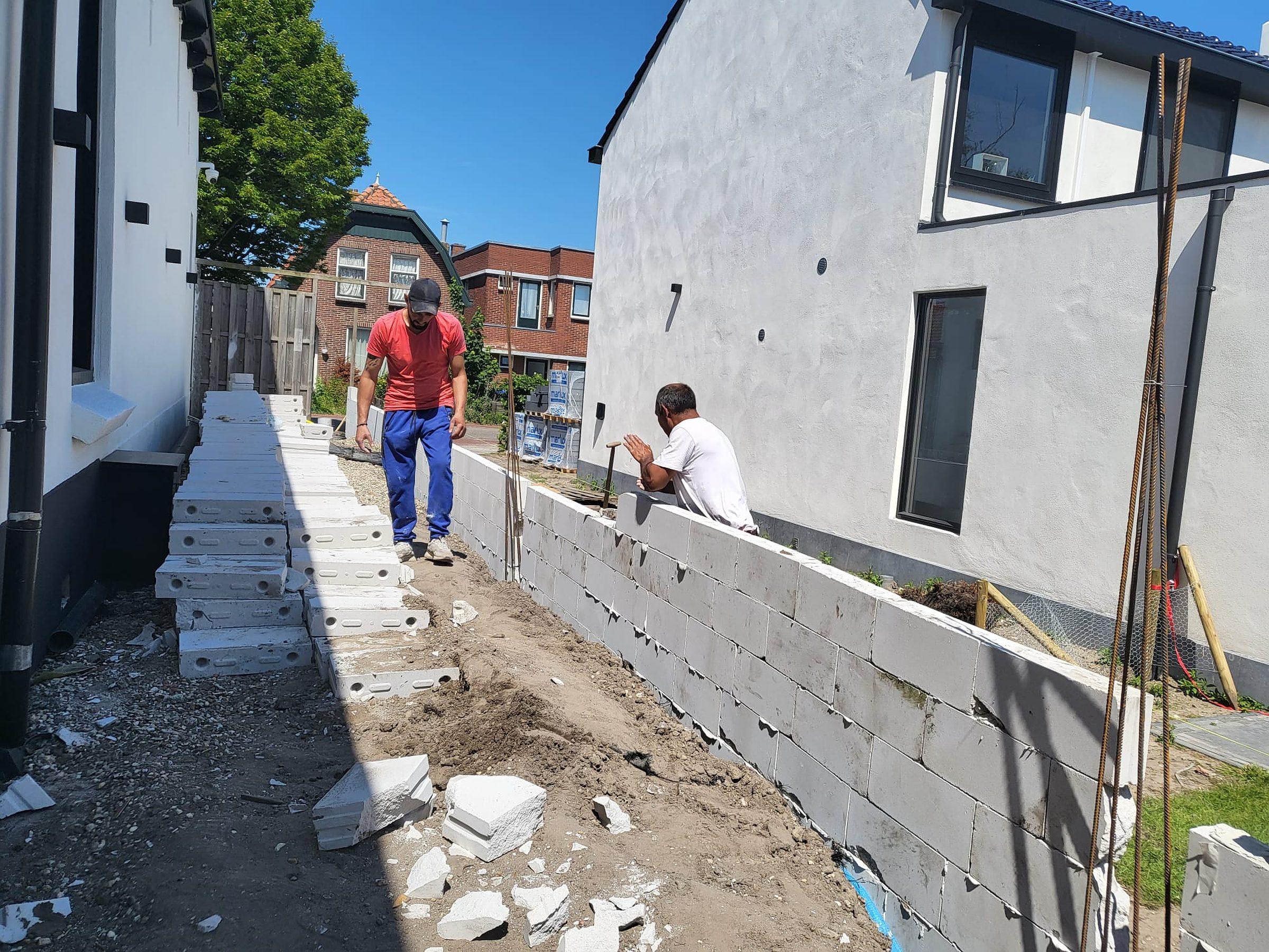 Tuinmuur in opbouw, blokken gemetseld.