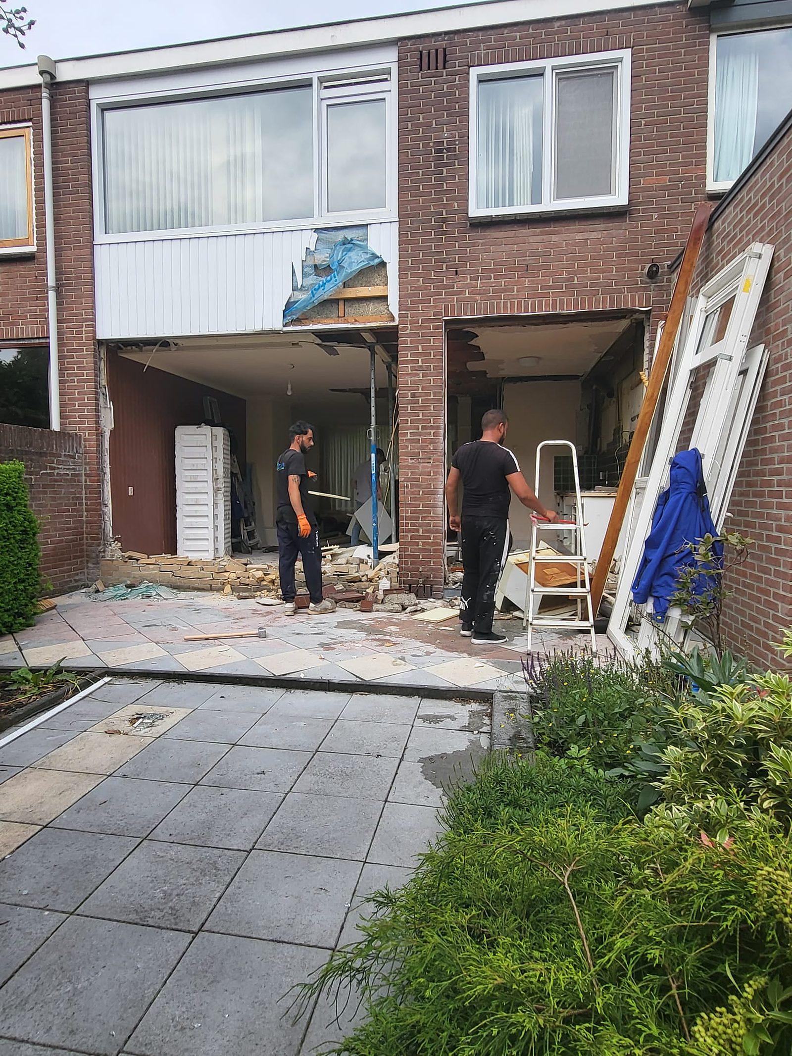 Afgeronde overkapping met tegelterras, gezien vanuit de tuin.