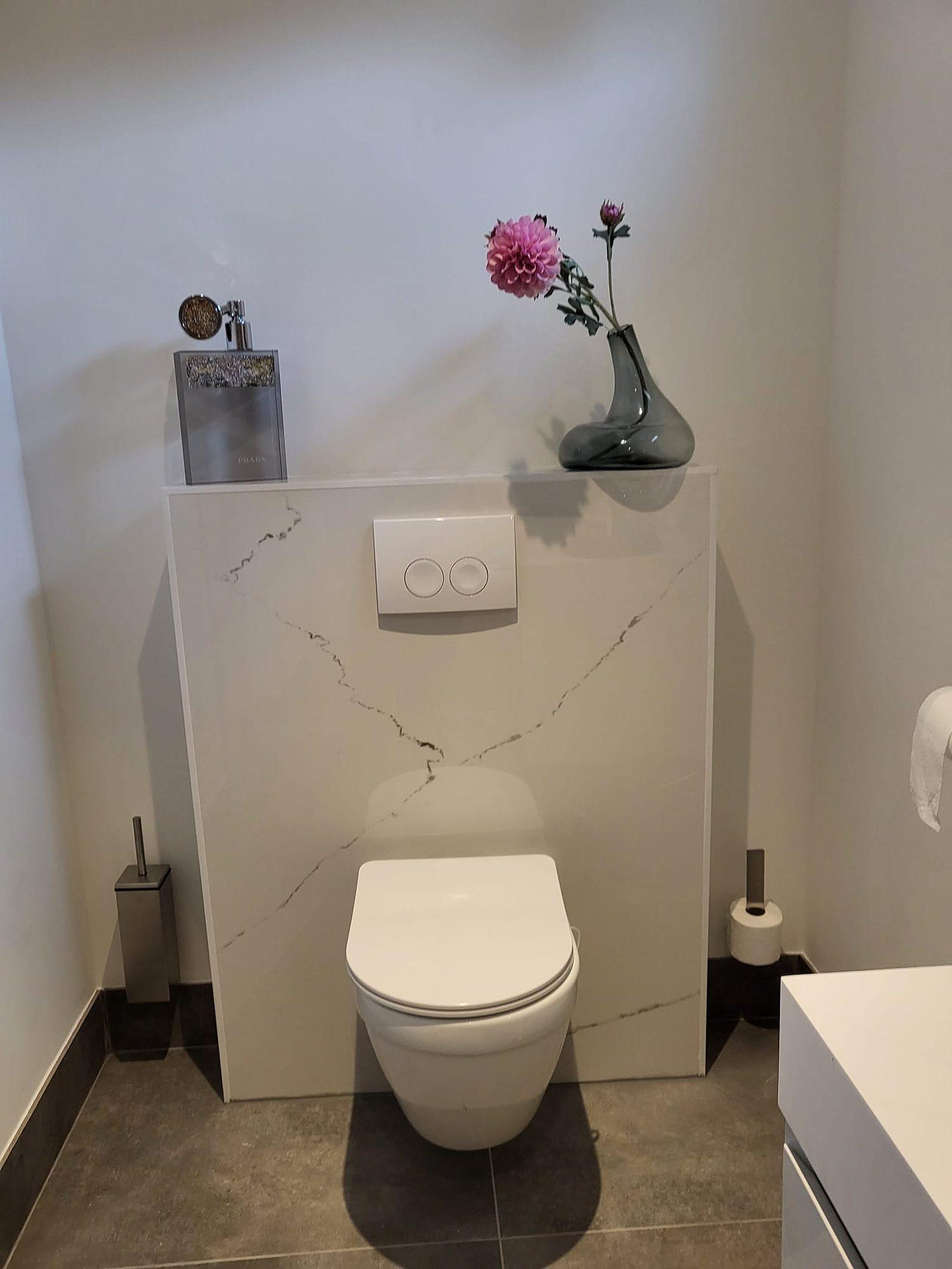 Hangend toilet met marmerlook wand.