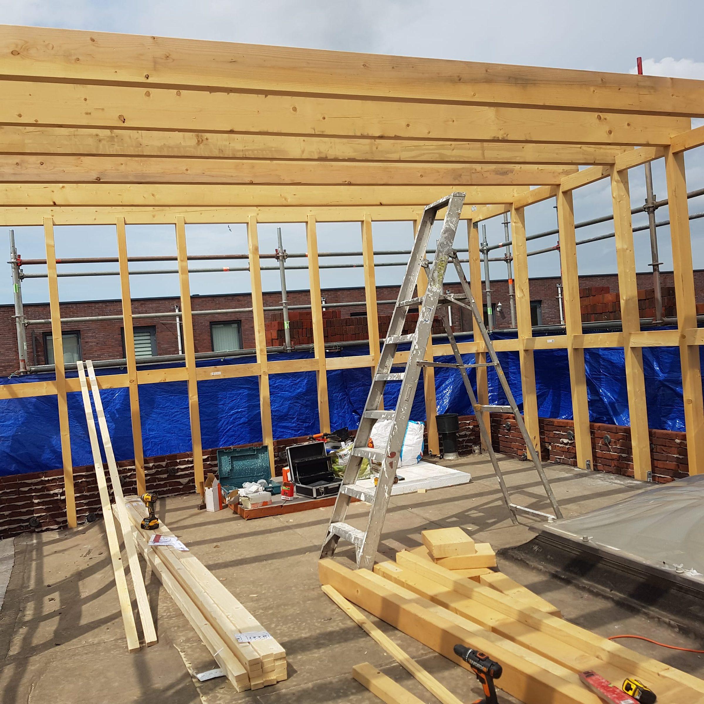 Wandafwerking in aanbouw (drywall en houten kozijn).
