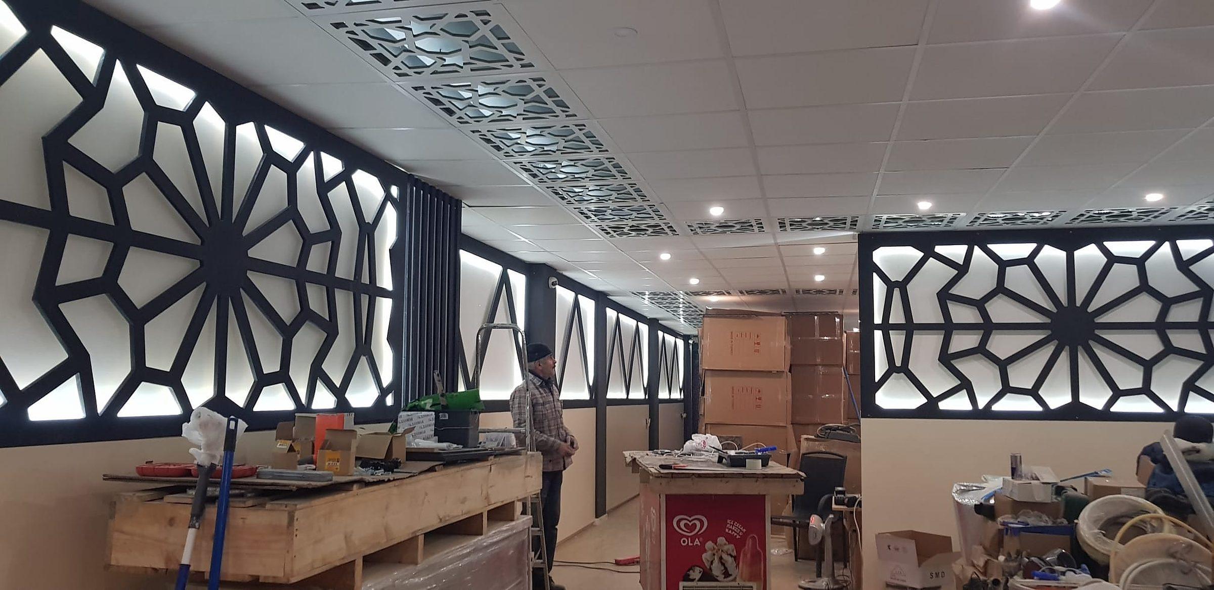 Ruimte met verlaagd plafond vol CNC-gefreesde lichtpanelen.
