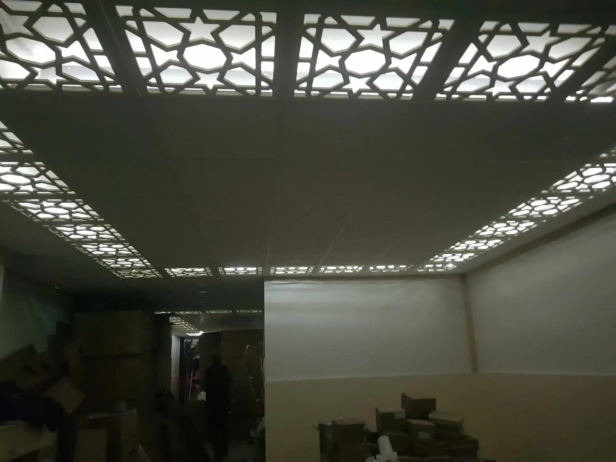 Verlaagd plafond met ingesneden sterpatroon, van onderaf gezien; het licht schijnt door de openingen.