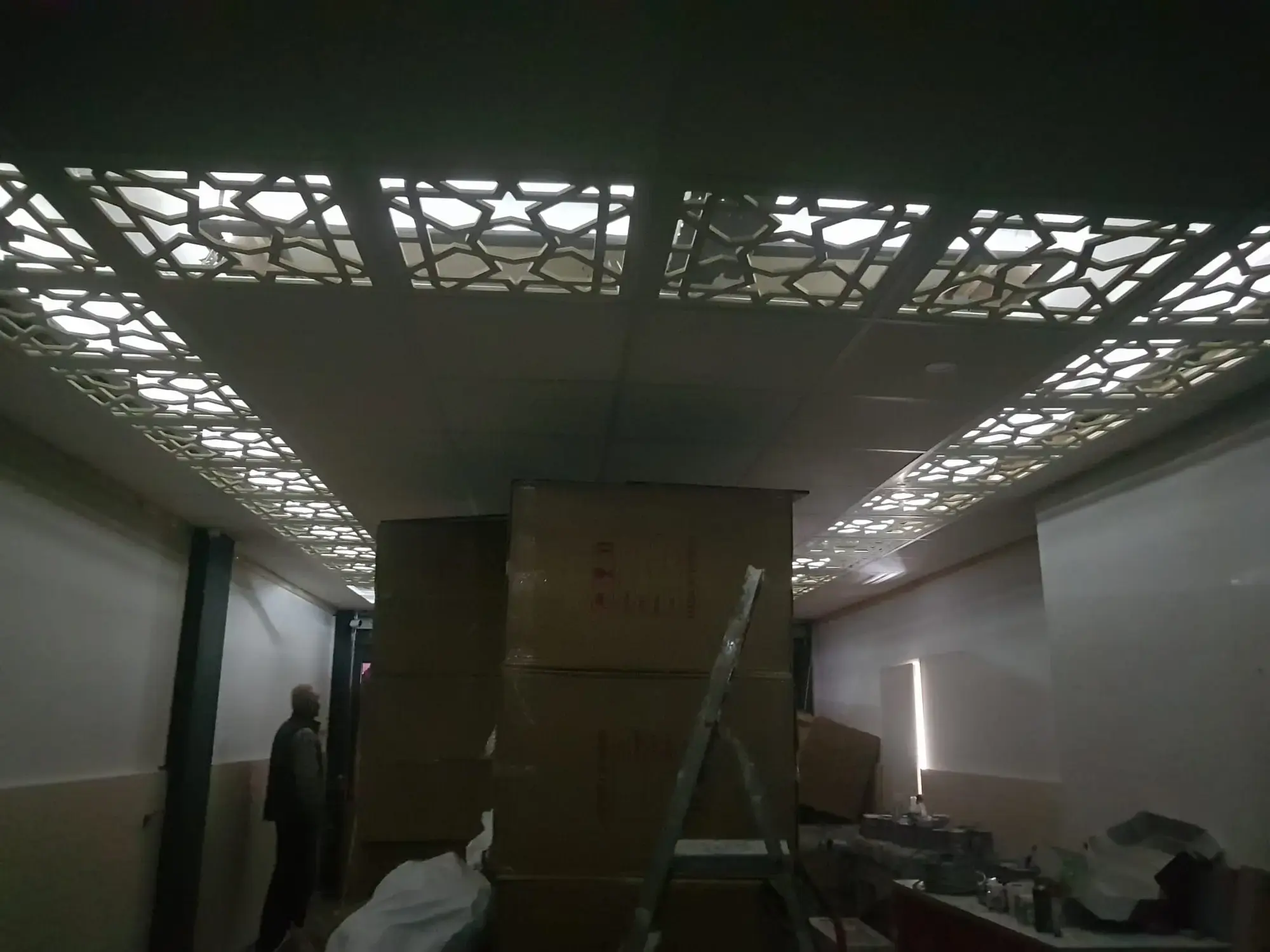 Dezelfde verlaagde plafondpanelen vanuit een andere hoek van de ruimte, tijdens de montage.